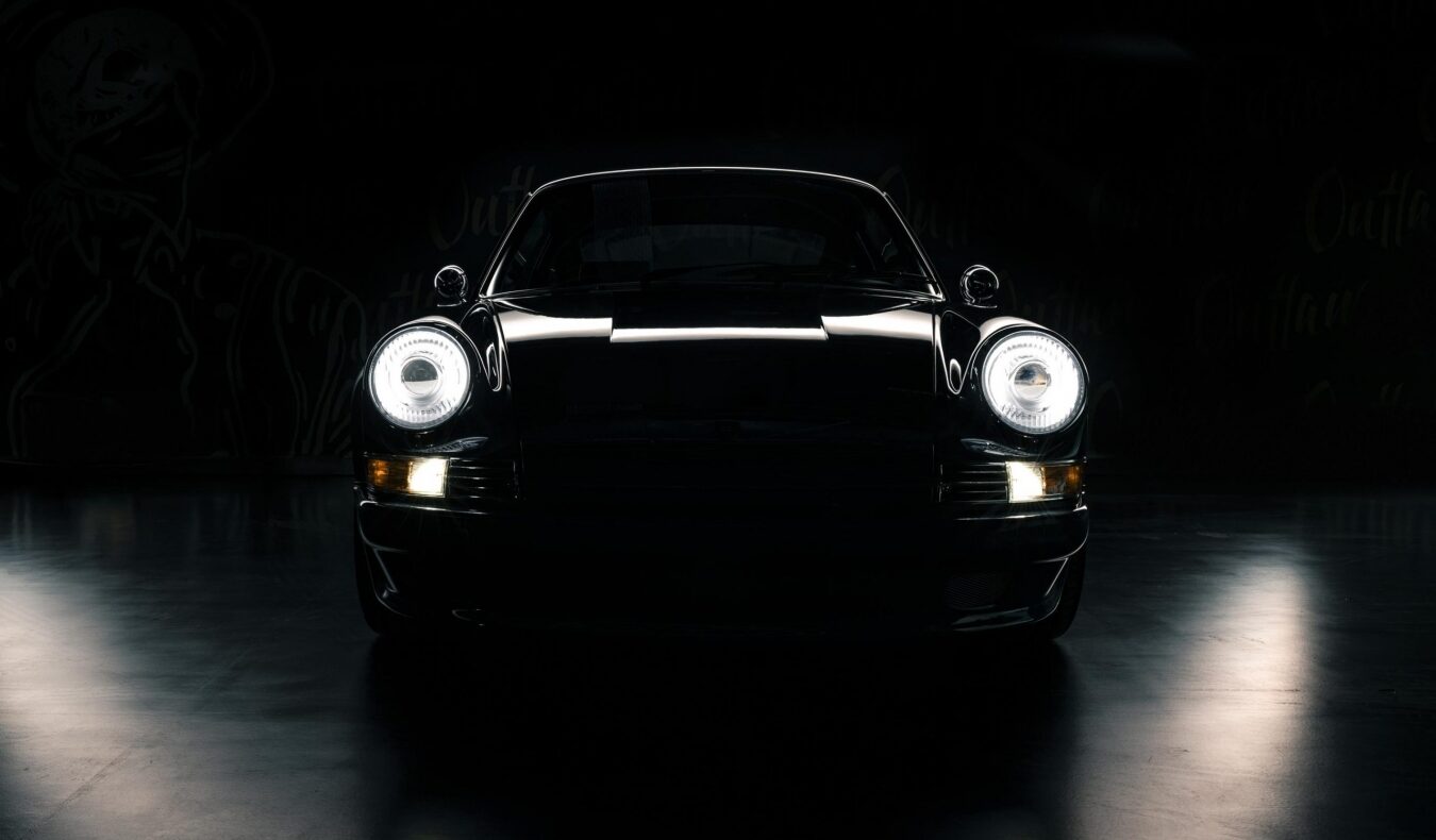 Фирменные круглые фары Porsche 911 в темноте